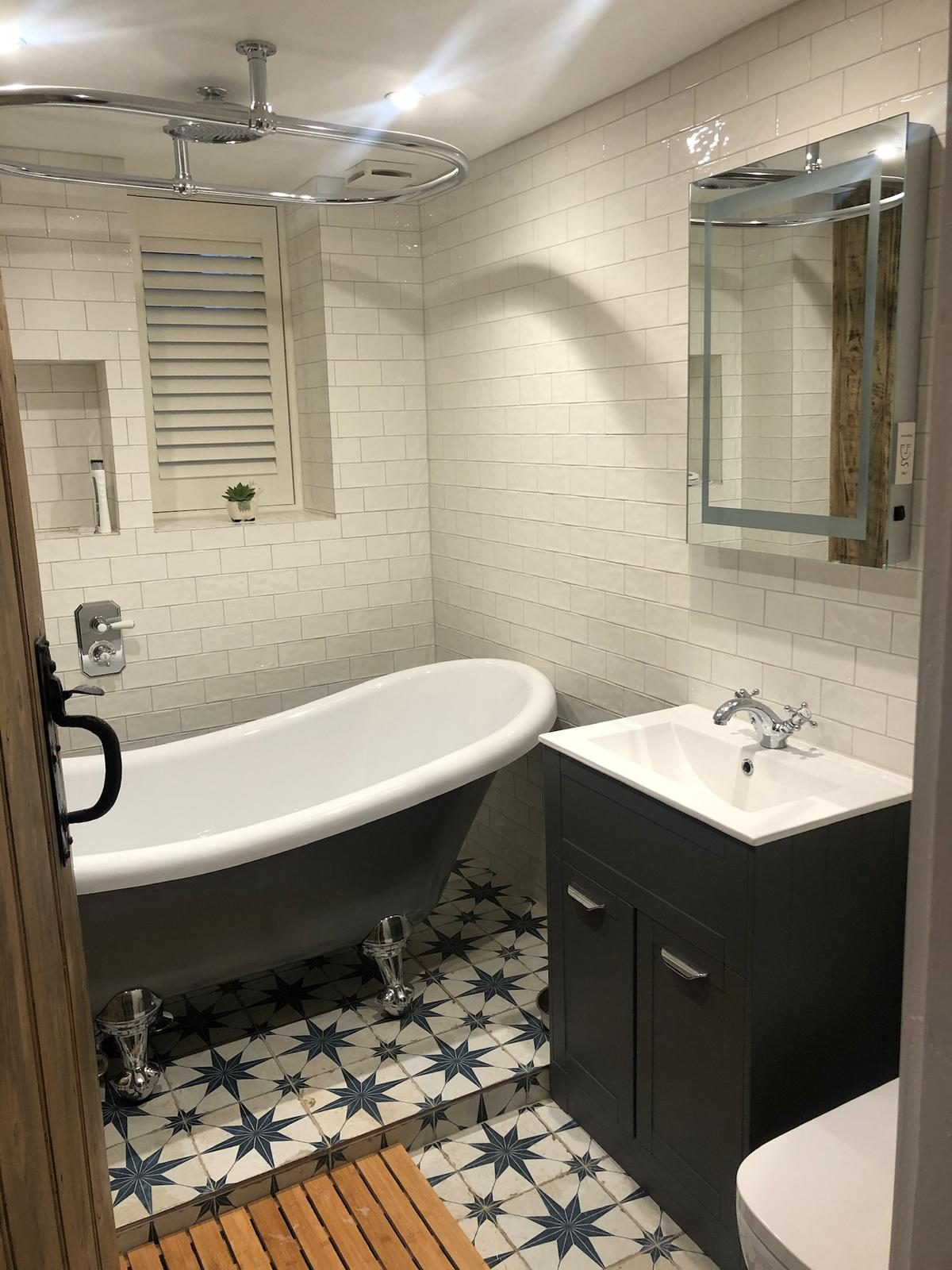 Family bathroom with oval shower curtain rail and subway tile