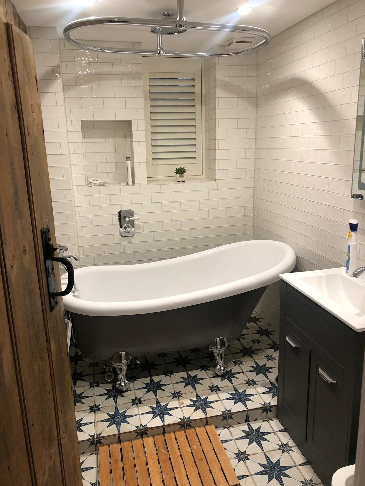 Family bathroom with claw-foot bath, dark vanity and star floor