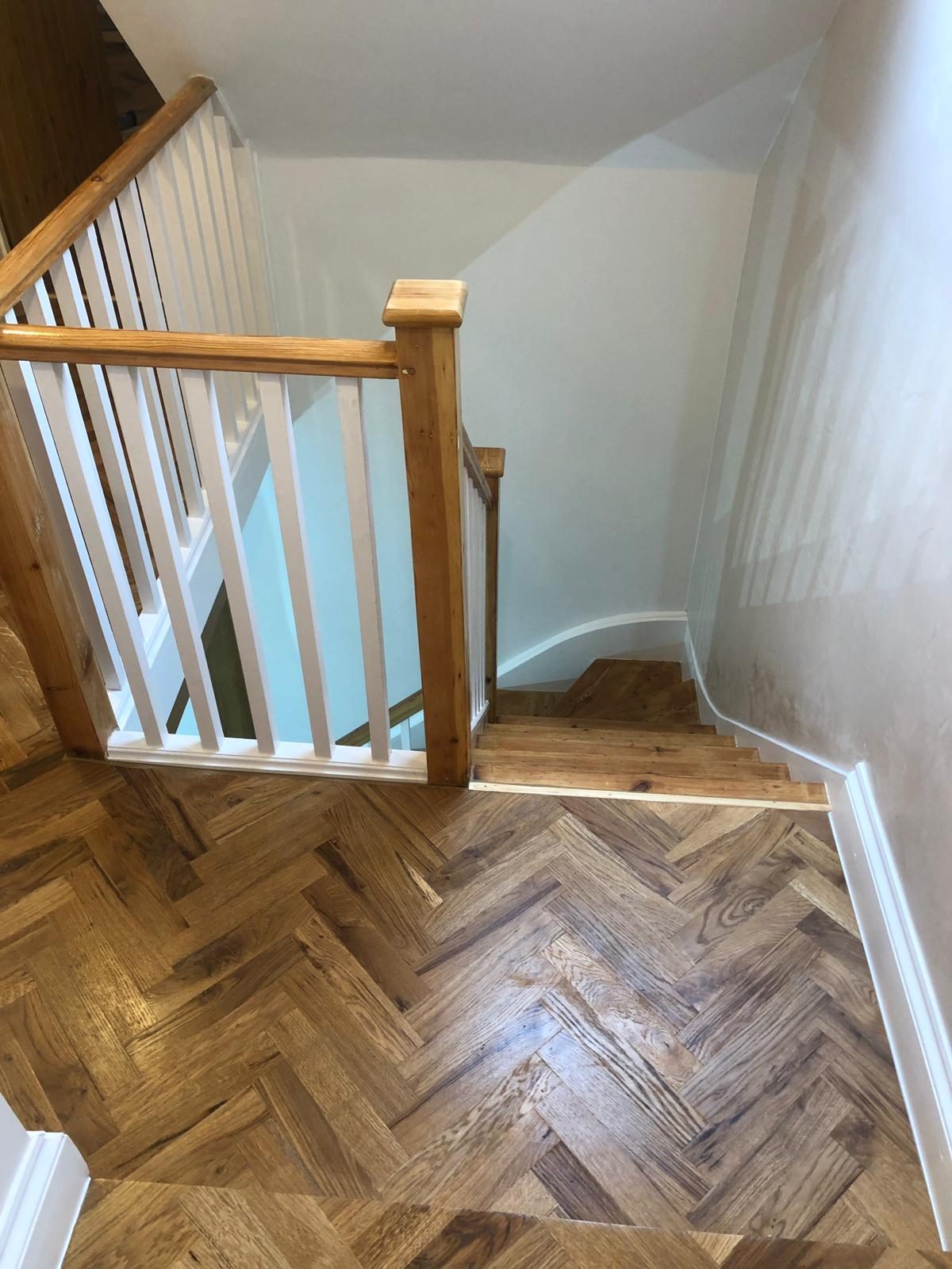Stair landing with new herringbone parquet and refinished balustrade